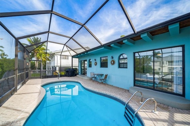 pool featuring a patio and glass enclosure