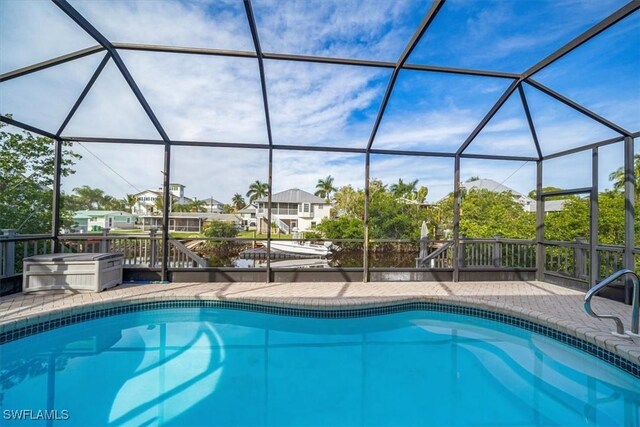 outdoor pool featuring a patio area and glass enclosure