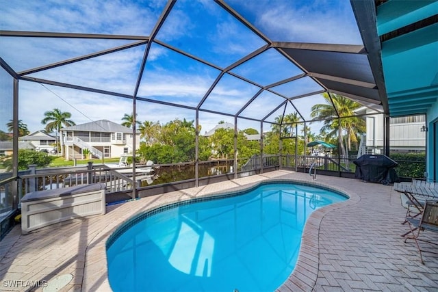 outdoor pool with area for grilling, a patio, and glass enclosure