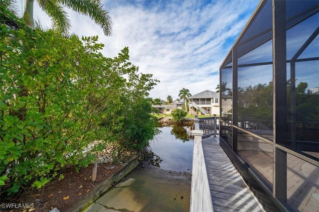 dock area featuring a water view and glass enclosure