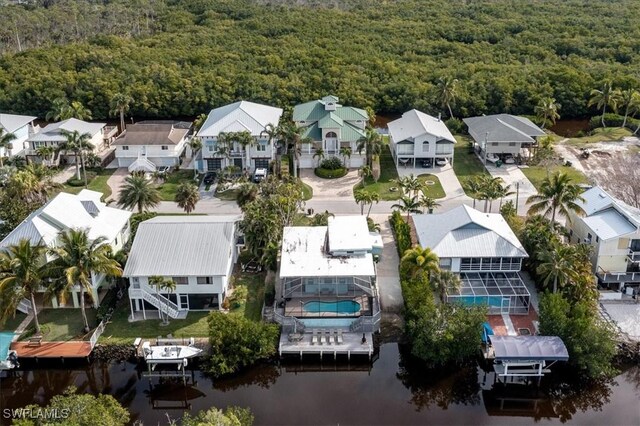 aerial view featuring a wooded view, a residential view, and a water view