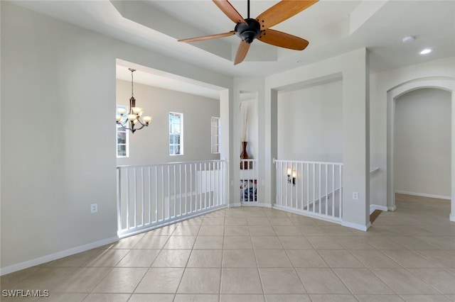 unfurnished room with light tile patterned floors, baseboards, and ceiling fan with notable chandelier