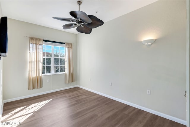 empty room featuring baseboards, ceiling fan, and dark wood-style floors