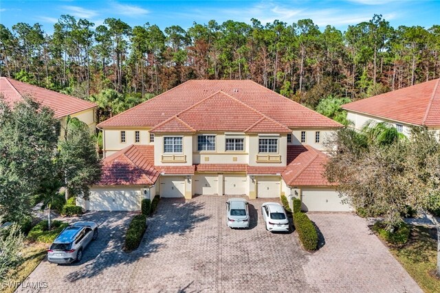 mediterranean / spanish home featuring stucco siding, decorative driveway, and a tile roof
