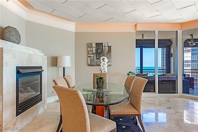 81 Seagate Dr Unit 1101, Naples, FL 34103 - dining space featuring crown molding, a glass covered fireplace, and marble tiled floors