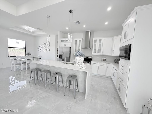 kitchen with visible vents, wall chimney exhaust hood, appliances with stainless steel finishes, a spacious island, and marble finish floor