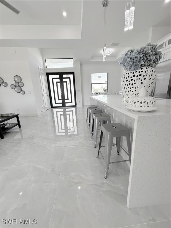dining space featuring a raised ceiling and marble finish floor
