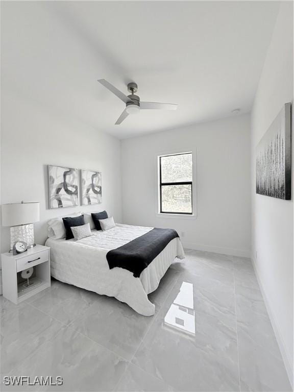 bedroom with ceiling fan, marble finish floor, and baseboards