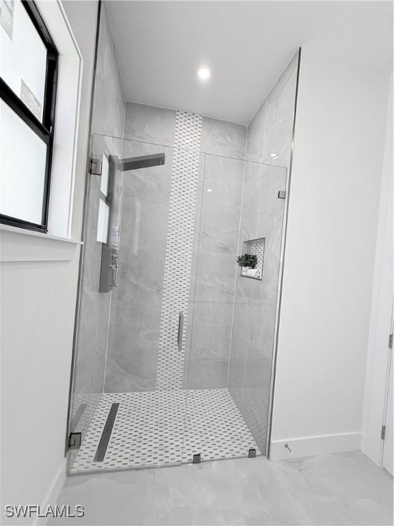bathroom with baseboards and a shower stall