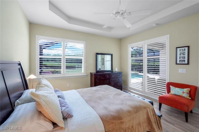 9102 Limestone Ln, Naples, FL 34120 - bedroom with a tray ceiling, wood finished floors, baseboards, and a ceiling fan