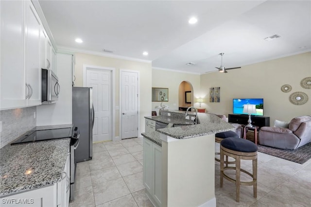 9102 Limestone Ln, Naples, FL 34120 - kitchen featuring arched walkways, ornamental molding, visible vents, appliances with stainless steel finishes, and open floor plan