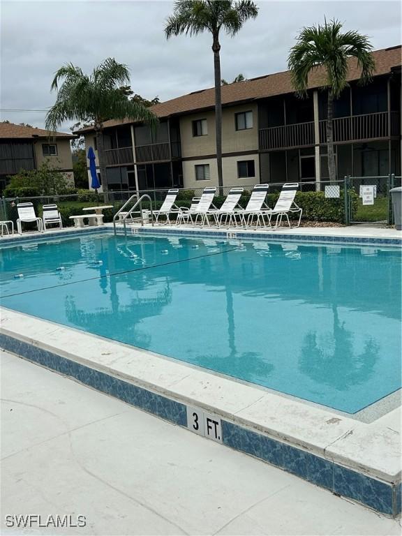 view of swimming pool featuring fence