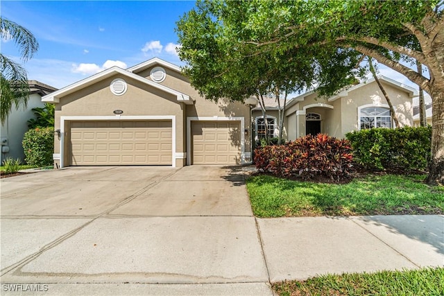 167 Burnt Pine Dr, Naples, FL 34119 - view of front of property featuring stucco siding, driveway, and a garage