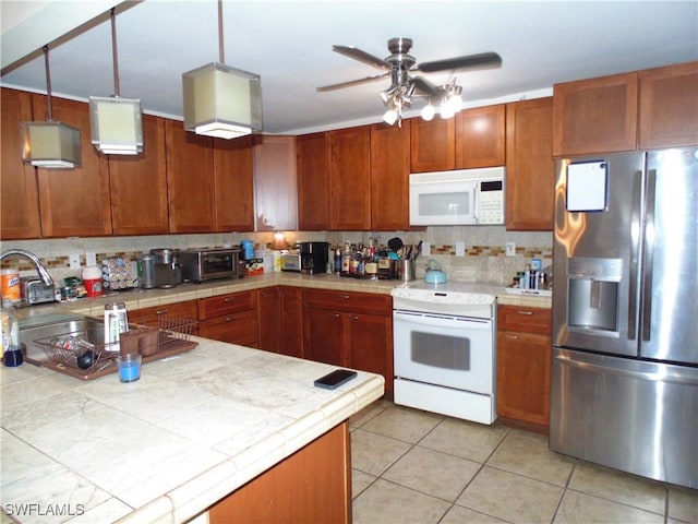 18215 Iris Rd, Fort Myers, FL 33967 - kitchen featuring tasteful backsplash, white appliances, tile countertops, and a sink