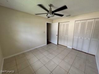 18215 Iris Rd, Fort Myers, FL 33967 - unfurnished bedroom with two closets, light tile patterned flooring, and a ceiling fan