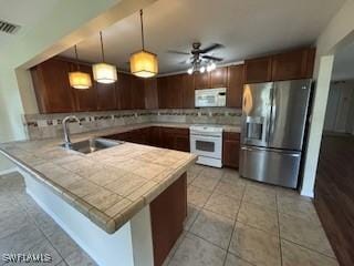 18215 Iris Rd, Fort Myers, FL 33967 - kitchen with white appliances, a peninsula, tasteful backsplash, a ceiling fan, and light tile patterned flooring