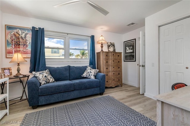 living area featuring a ceiling fan, light wood-style floors, and visible vents