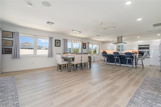 dining area with baseboards, light wood-style floors, visible vents, and recessed lighting