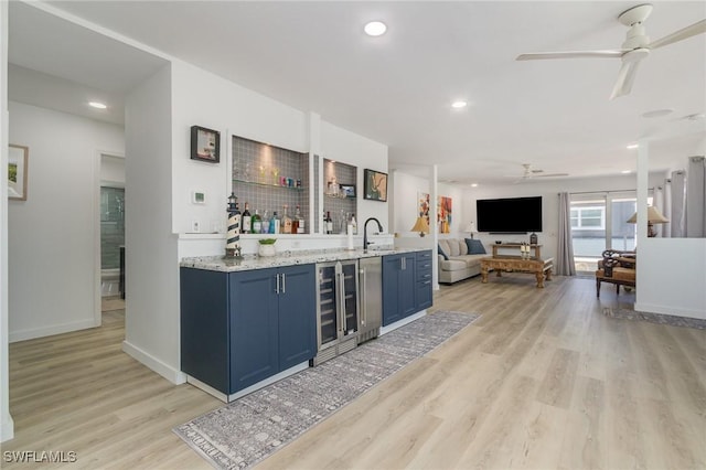 bar with wine cooler, light wood-style flooring, recessed lighting, bar, and a ceiling fan