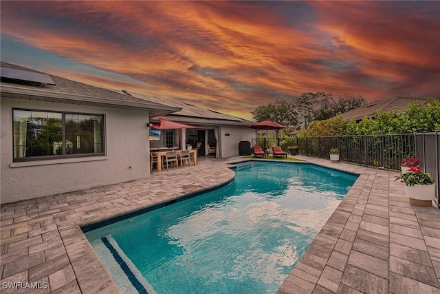 171 Palmetto Dunes Cir, Naples, FL 34113 - pool at dusk with a patio and outdoor dining space