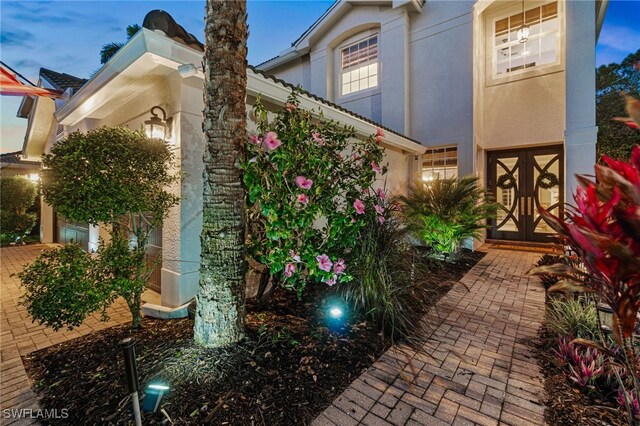 view of property exterior with french doors and stucco siding