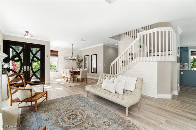 living room with stairway, baseboards, an inviting chandelier, and wood finished floors