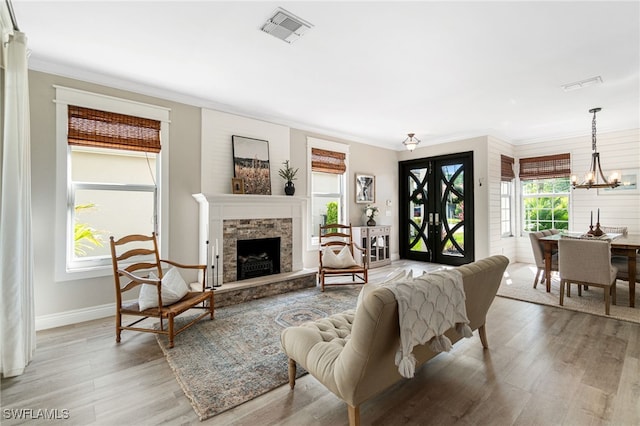 living area with visible vents, ornamental molding, and light wood finished floors