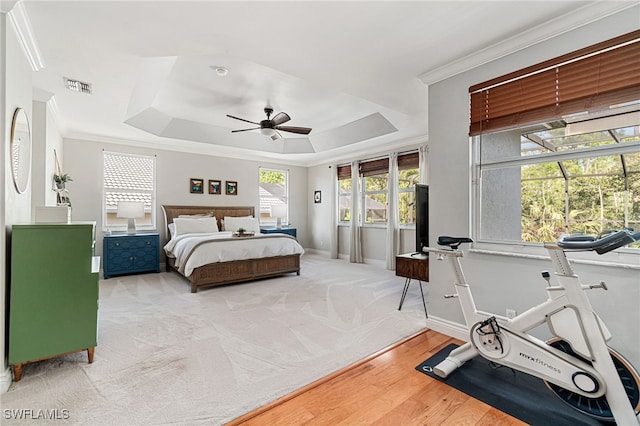 bedroom with visible vents, baseboards, crown molding, and a tray ceiling
