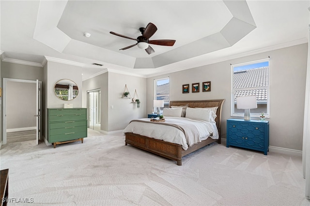 bedroom featuring crown molding, baseboards, light carpet, and a raised ceiling