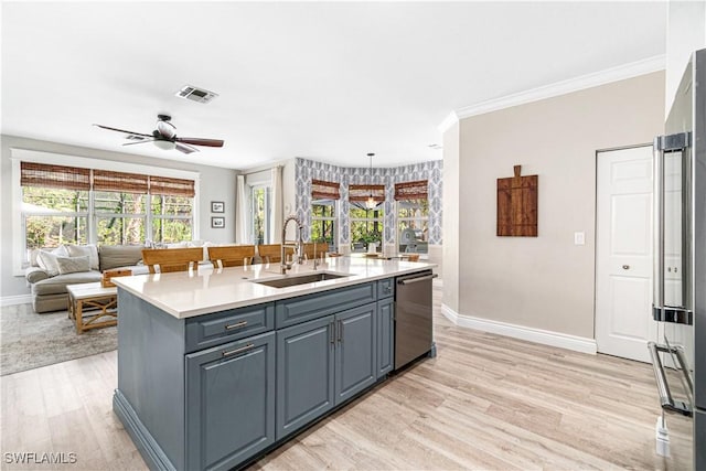 kitchen featuring a sink, dishwasher, baseboards, light wood-type flooring, and visible vents