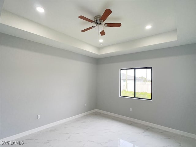 1103 Tropicana Pkwy W, Cape Coral, FL 33993 - spare room featuring baseboards, a raised ceiling, ceiling fan, recessed lighting, and marble finish floor