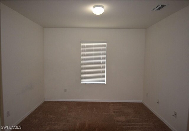 carpeted empty room featuring visible vents and baseboards