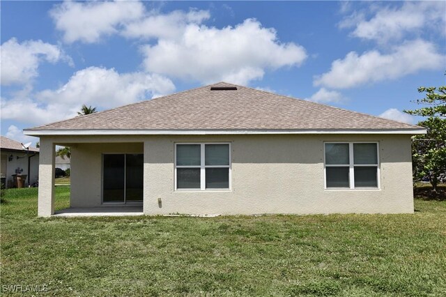 back of house with a yard and stucco siding