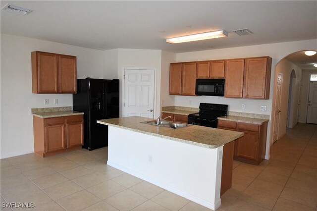 kitchen with brown cabinets, visible vents, black appliances, and arched walkways