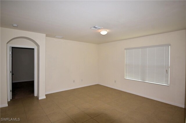 unfurnished room featuring baseboards and visible vents