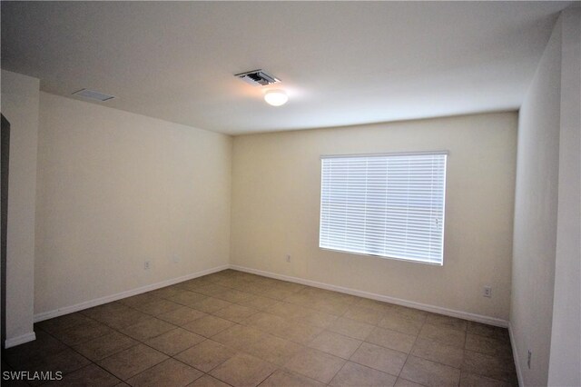 empty room featuring baseboards and visible vents