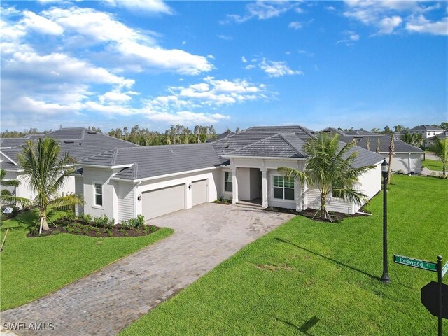 25155 Redwood Ct, Punta Gorda, FL 33955 - ranch-style house featuring a tiled roof, stucco siding, decorative driveway, a front lawn, and an attached garage