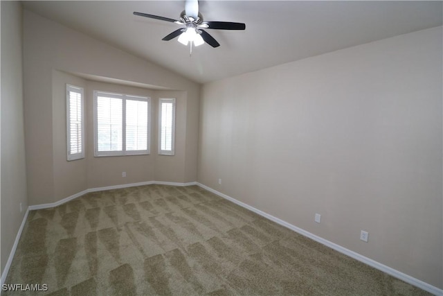 empty room featuring ceiling fan, light colored carpet, baseboards, and lofted ceiling