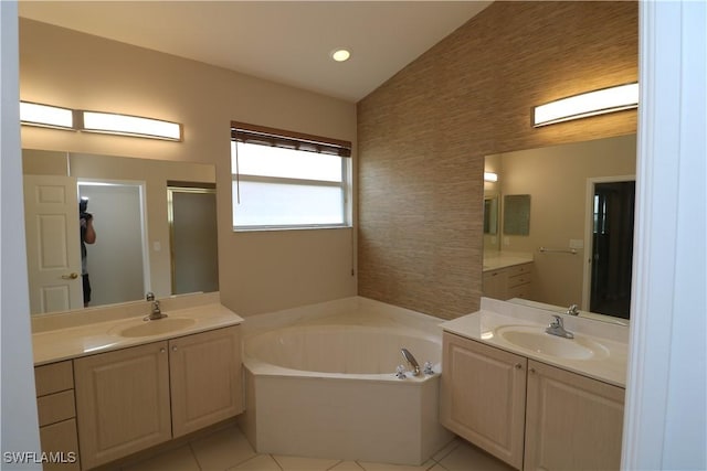 bathroom featuring a shower stall, a garden tub, a sink, and tile patterned flooring