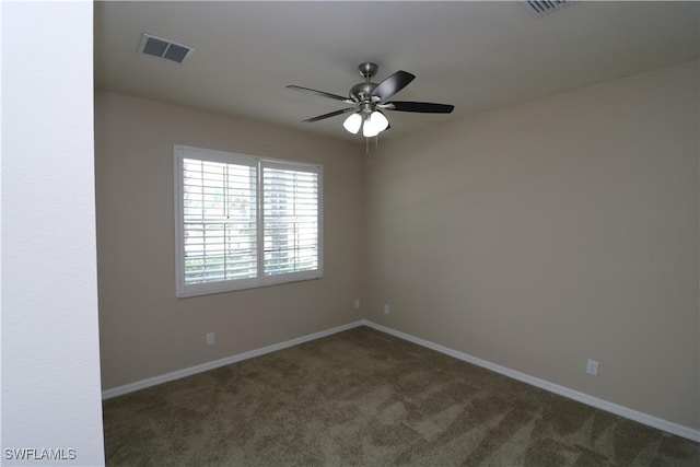 carpeted empty room with visible vents, ceiling fan, and baseboards