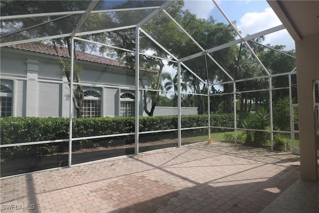 view of patio featuring glass enclosure