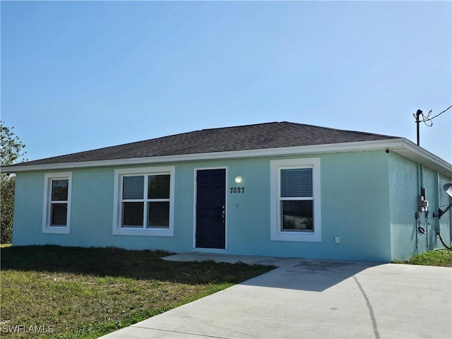7027 Palpano Cir, Labelle, FL 33935 - ranch-style home with a front yard, roof with shingles, and stucco siding
