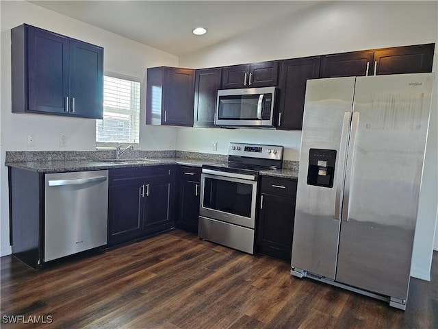 7027 Palpano Cir, Labelle, FL 33935 - kitchen featuring dark stone counters, vaulted ceiling, dark wood-style flooring, a sink, and stainless steel appliances