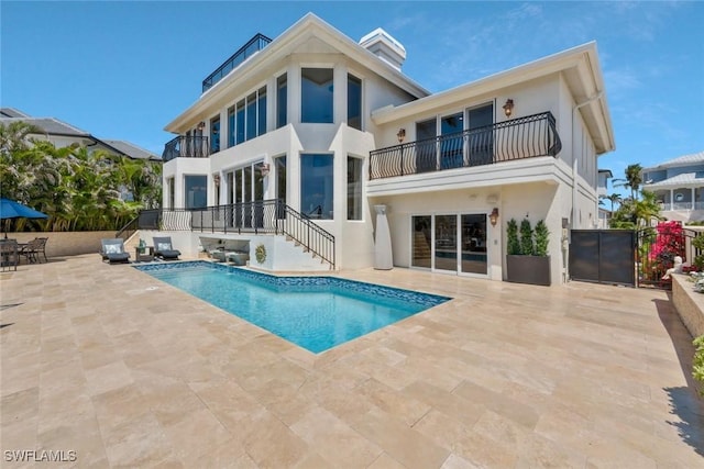 152 Conners Ave, Naples, FL 34108 - rear view of house with a fenced in pool, a patio, a balcony, and stucco siding