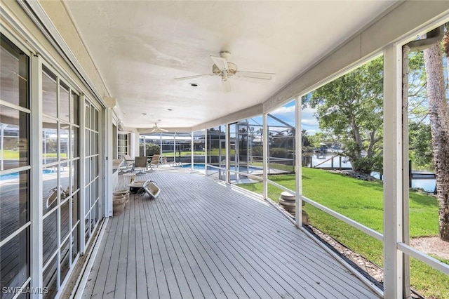 unfurnished sunroom with a water view and a ceiling fan