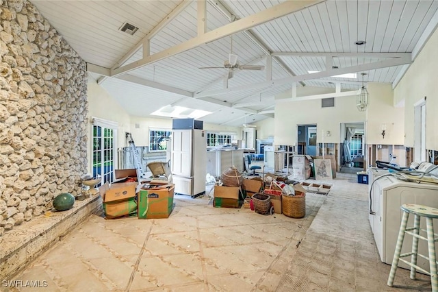 interior space with high vaulted ceiling, visible vents, washing machine and clothes dryer, and a ceiling fan