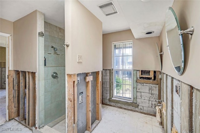 bathroom with visible vents and tiled shower