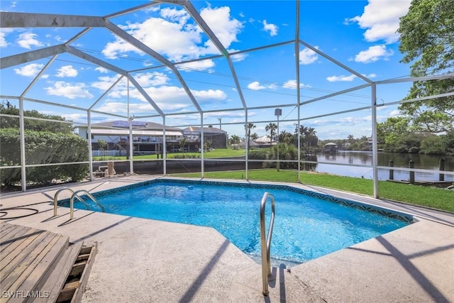 outdoor pool with a water view, glass enclosure, a lawn, and a patio area