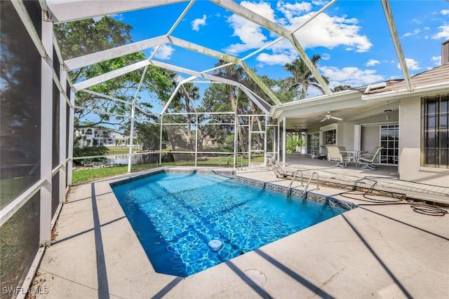 outdoor pool featuring a water view, a patio, glass enclosure, and a ceiling fan