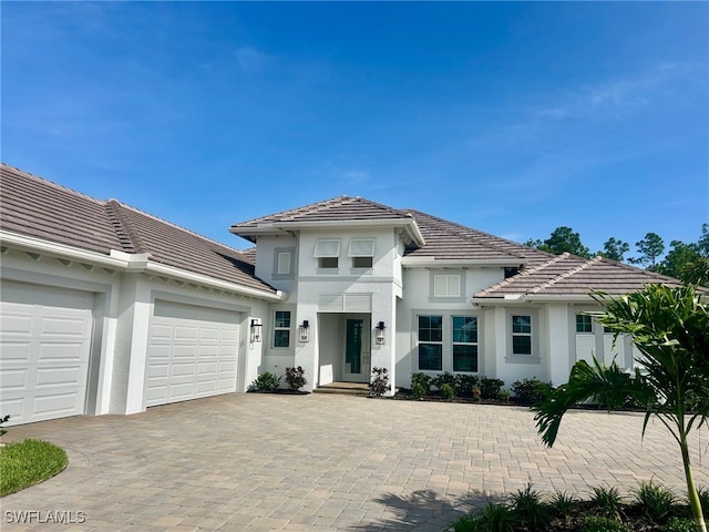 9499 Caymas Way, Naples, FL 34114 - view of front of house featuring a tile roof, stucco siding, driveway, and a garage